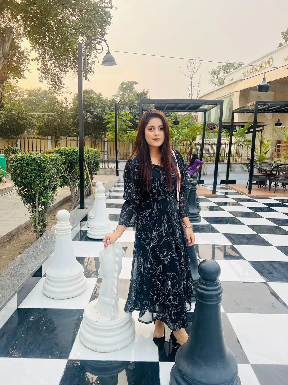 Hafsa Safdar standing among oversized chess pieces